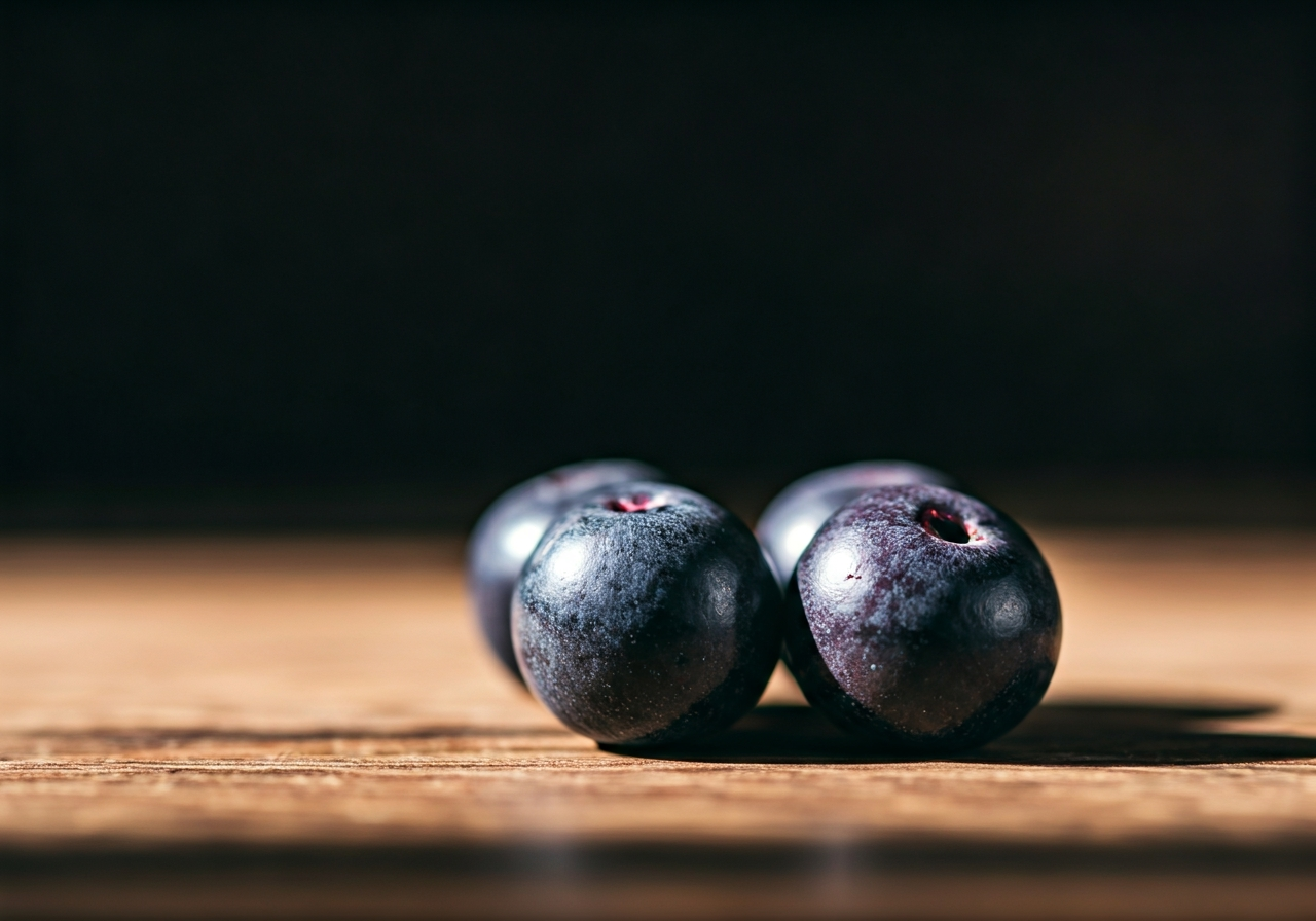 Maqui: Opravdu funguje? (Pravda o detoxu v roce 2026) 2 A macro, high-resolution shot of fresh, deep purple Maqui berries resting on a natural wooden surface with soft morning light, editorial food photography, 85mm lens, minimalist and organic aesthetic, no text, no words, no letters.
