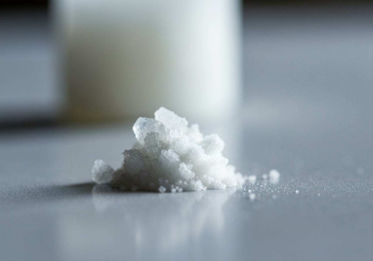 A scientific macro shot of crystalline ascorbic acid powder on a clean laboratory surface, soft natural light, shallow depth of field, 85mm lens, minimalist aesthetic, no text, no words, no letters.